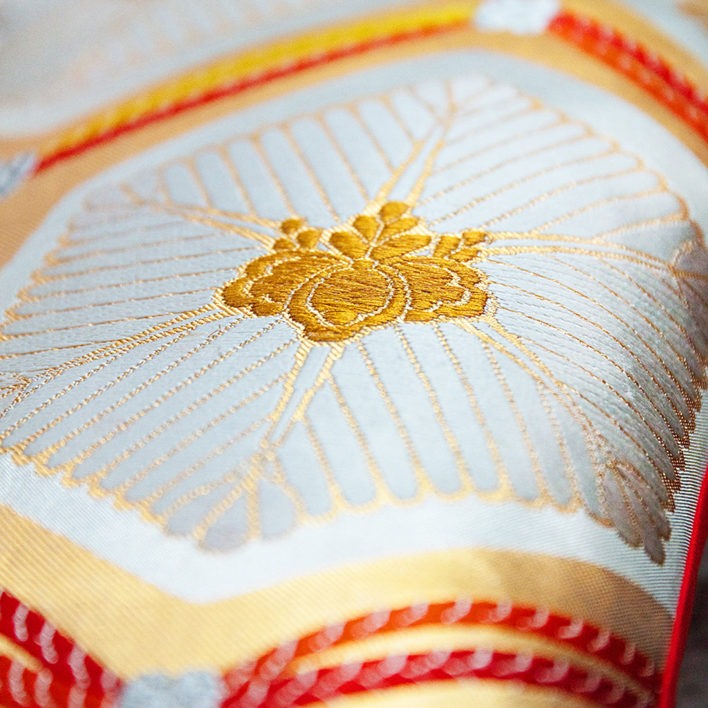 Close-up of gold metallic sheen and intricate texture of upcycled Japanese silk on the cushion’s corner, highlighting