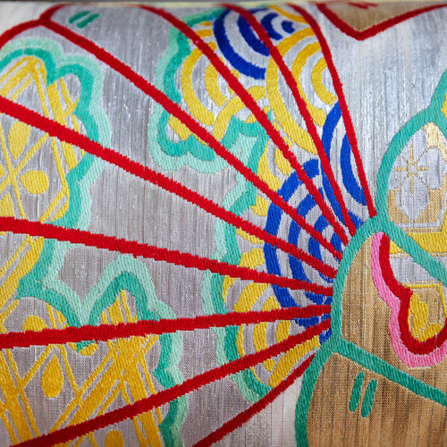 Close-up of yellow velvet fabric with vintage kimono silk fan embroidery highlighting intricate hand-stitching and textured