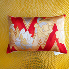 Close-up of red zigzag woven fabric and gold floral embroidery highlighting intricate texture detail of the vintage kimono