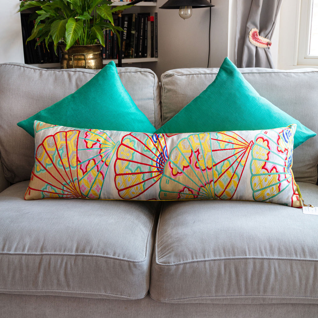 Close-up of the intricate kimono silk fan patterns adorning the yellow velvet bolster pillow edge, showcasing fine