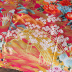 Close-up of the silk kimono's intricate floral embroidery and subtle sheen from a slightly angled perspective highlighting