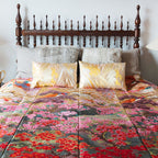 Close-up of the vintage kimono-inspired silk throw blanket's intricate floral stitching and satin finish in soft blush color.