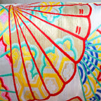 Close-up of golden yellow fabric with detailed embroidery of oriental fans on shimmering silver Kimono silk bolster cushion