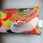 Close-up of colorful kimono silk cranes embroidered along the blue velvet bolster pillow edge, highlighting intricate thread