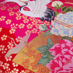 Close-up of pink silk and velvet textures highlighting intricate crane embroidery and vintage Uchikake style on the pillow