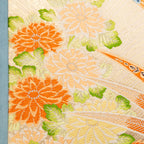 Close-up of cream Maru Obi silk and duck egg blue velvet fabric with subtle stitching details on the Flying Pheasants