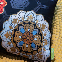 Detail of blue and gold flower on a black silk pillow made from vintage obi