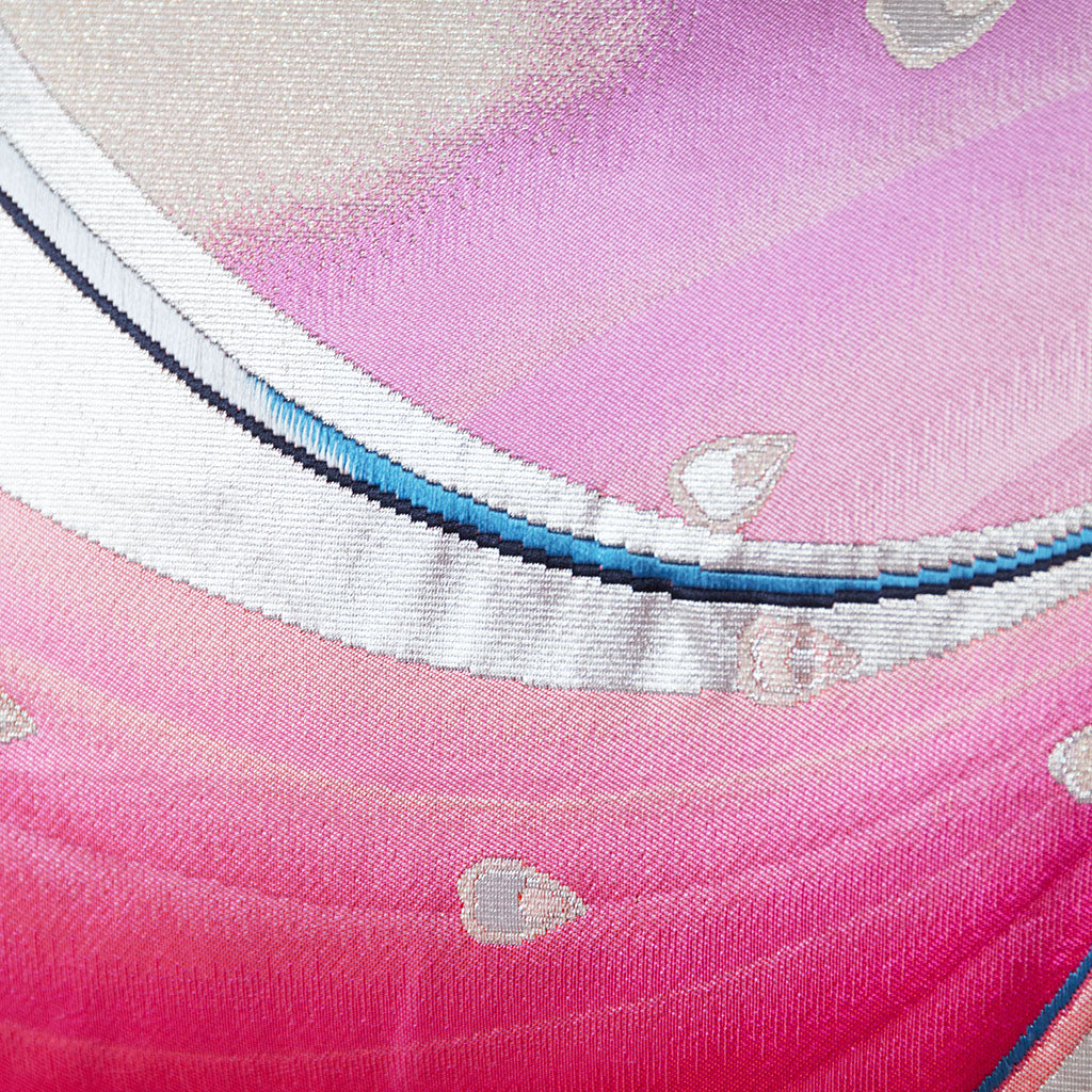 Close-up of the pink silk fabric highlighting intricate peacock embroidery and subtle sheen on vintage Japanese obi pillow.