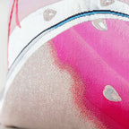 Close-up of pink silk fabric with silver obi pattern highlighting intricate woven details and subtle sheen from a slightly