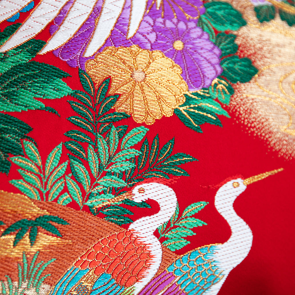 Close-up of the red silk embroidered details and textured black velvet background on the Wedding Uchikake cushion edge.