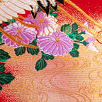 Close-up of red silk embroidery details on black velvet surface of the wedding Uchikake square cushion, showing intricate