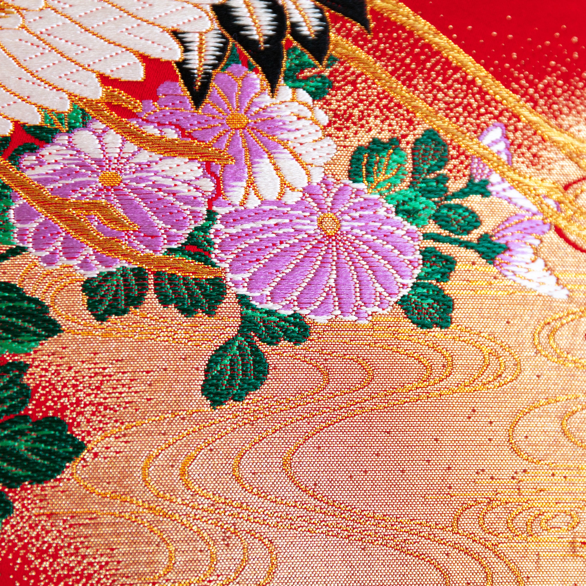 Close-up of red silk embroidery details on black velvet surface of the wedding Uchikake square cushion, showing intricate