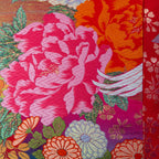 Close-up of pink silk and velvet embroidery detailing the flying cranes motif from a lower angle, highlighting intricate
