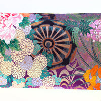 Detail of long silk pillow made from vintage kimono showing genji wheel and floral embroidery