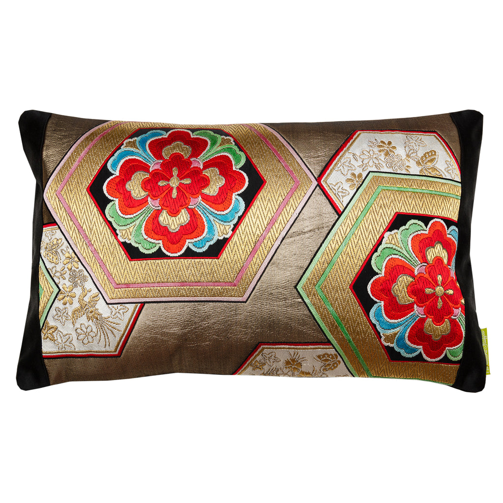 Close-up of the gold hexagon embroidery detail on black silk fabric, highlighting textured stitching and metallic sheen.