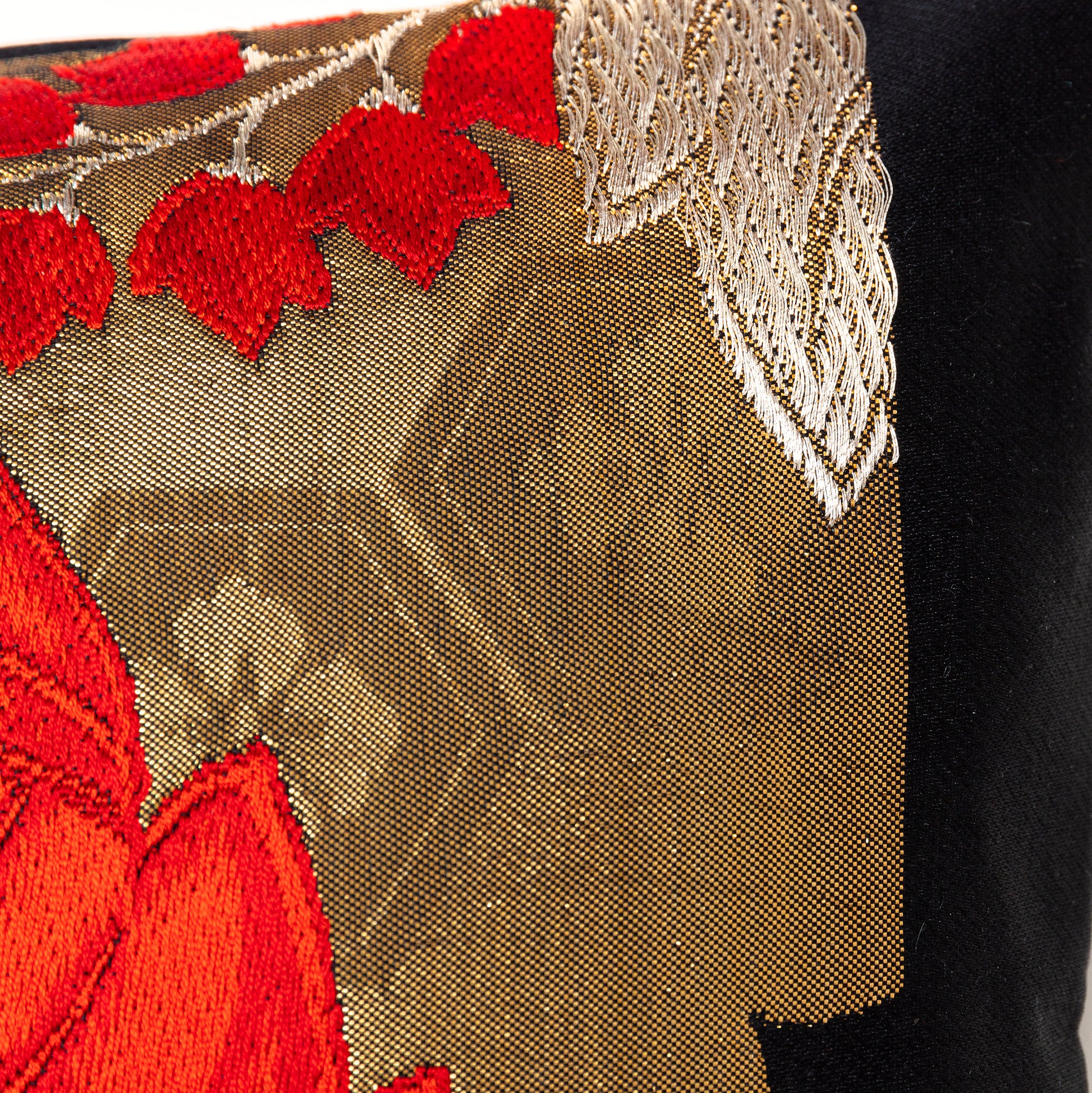 Gold accent cushion with red and black details.