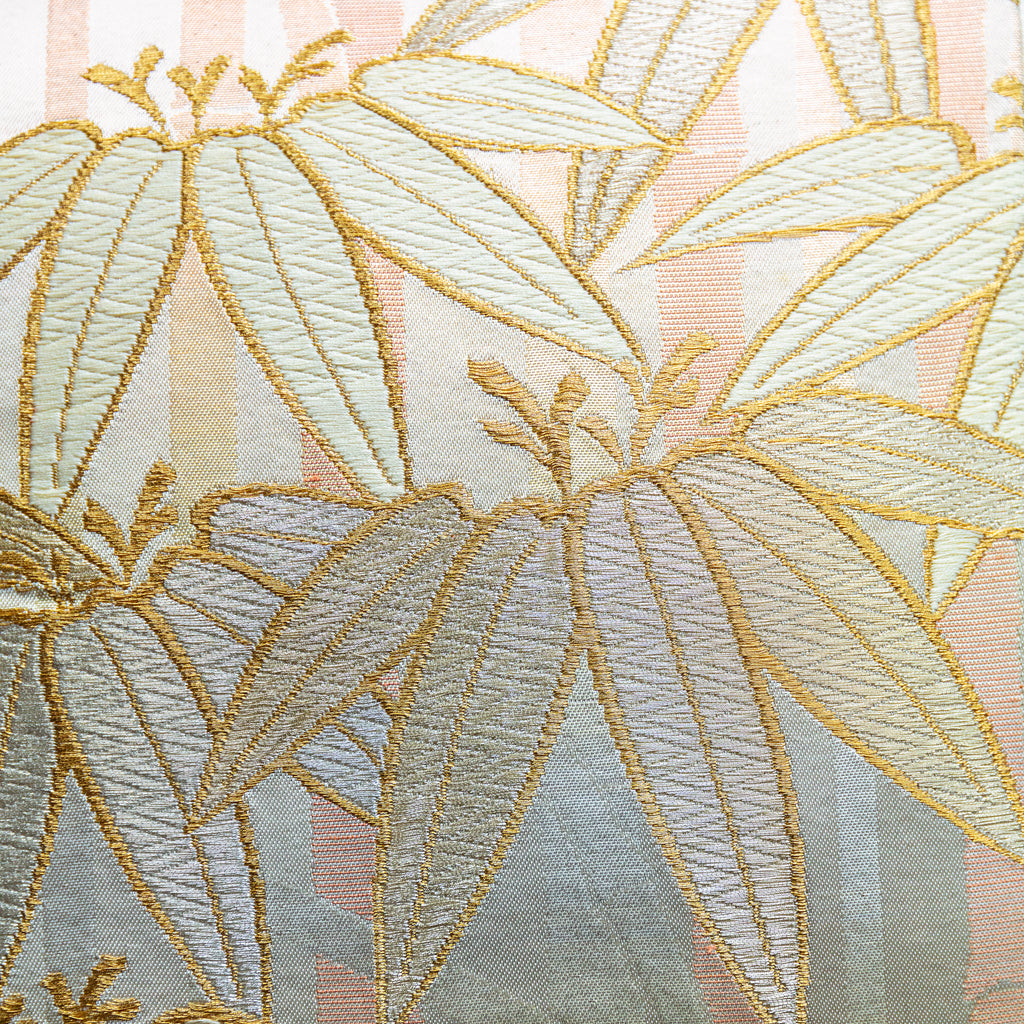 Close-up of the bamboo embroidery detail on the vintage gold pillow's peach velvet back, highlighting intricate stitching