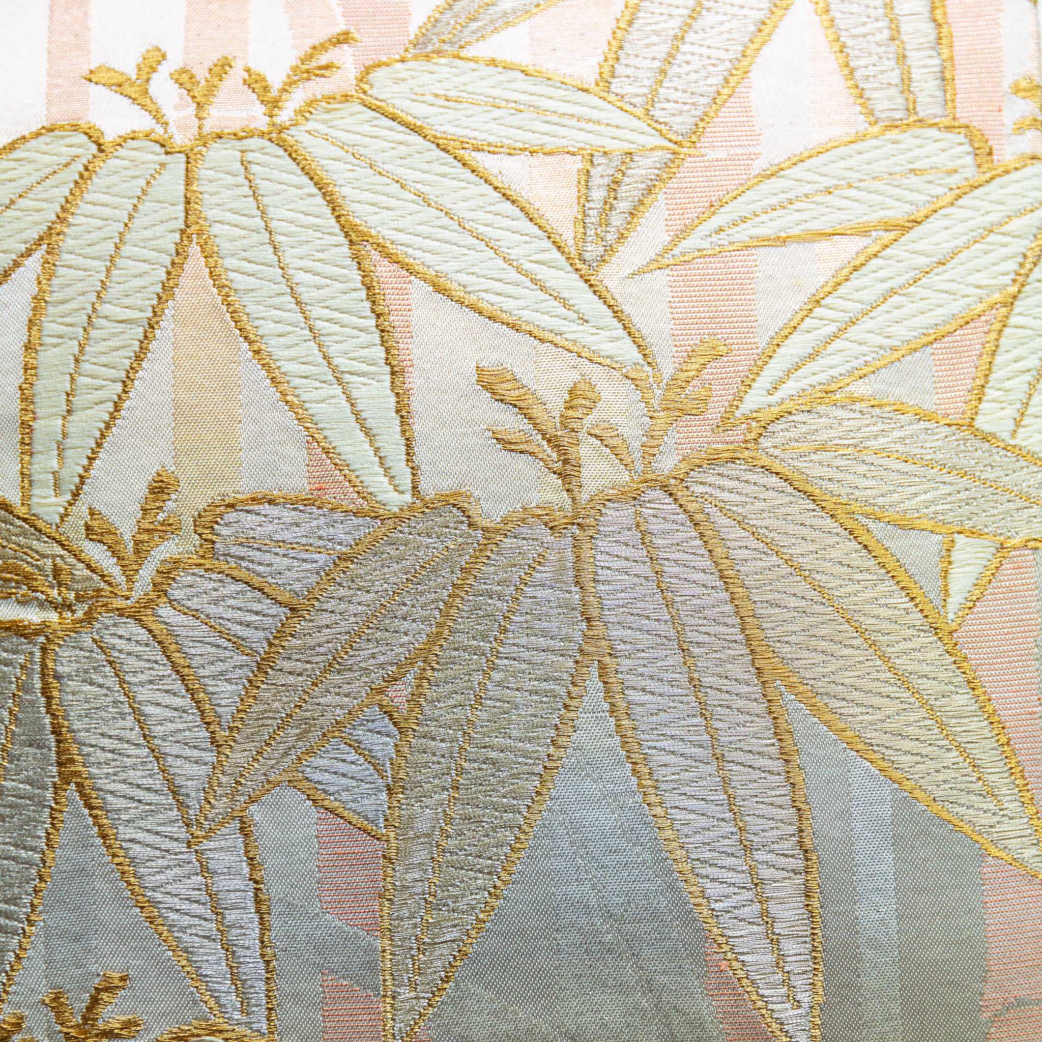 Close-up of the bamboo embroidery detail on the vintage gold pillow's peach velvet back, highlighting intricate stitching