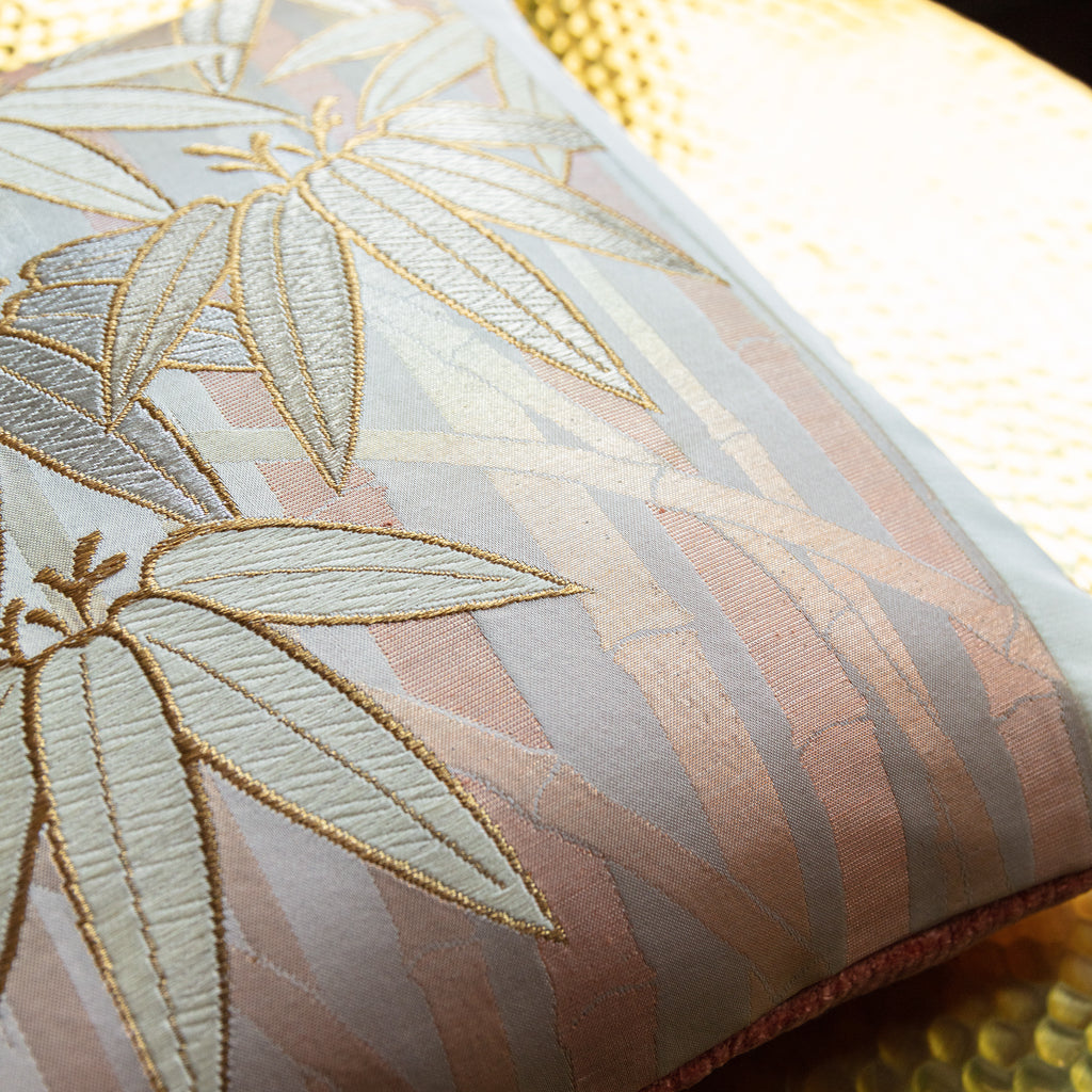 Close-up of the gold bamboo pattern highlighting intricate weave details on the vintage pillow's peach velvet back side.