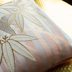 Close-up of the gold bamboo pattern highlighting intricate weave details on the vintage pillow's peach velvet back side.