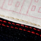 Close-up of navy wool tartan fabric detail highlighting vintage Gannex Ltd Ed branding on the cushion’s corner