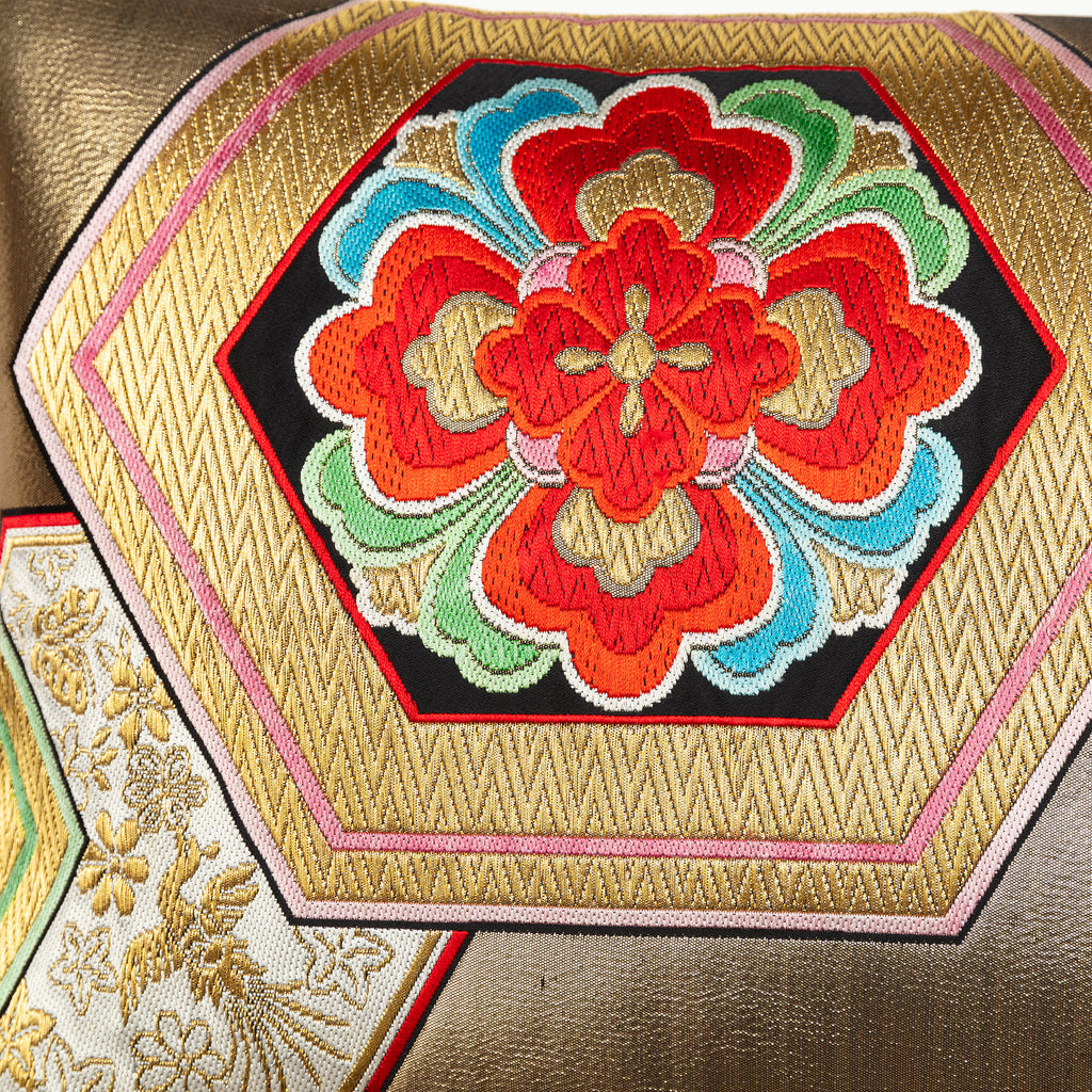 Close-up of gold hexagon embroidery on vintage Obi silk fabric showcasing intricate texture and rich metallic sheen.