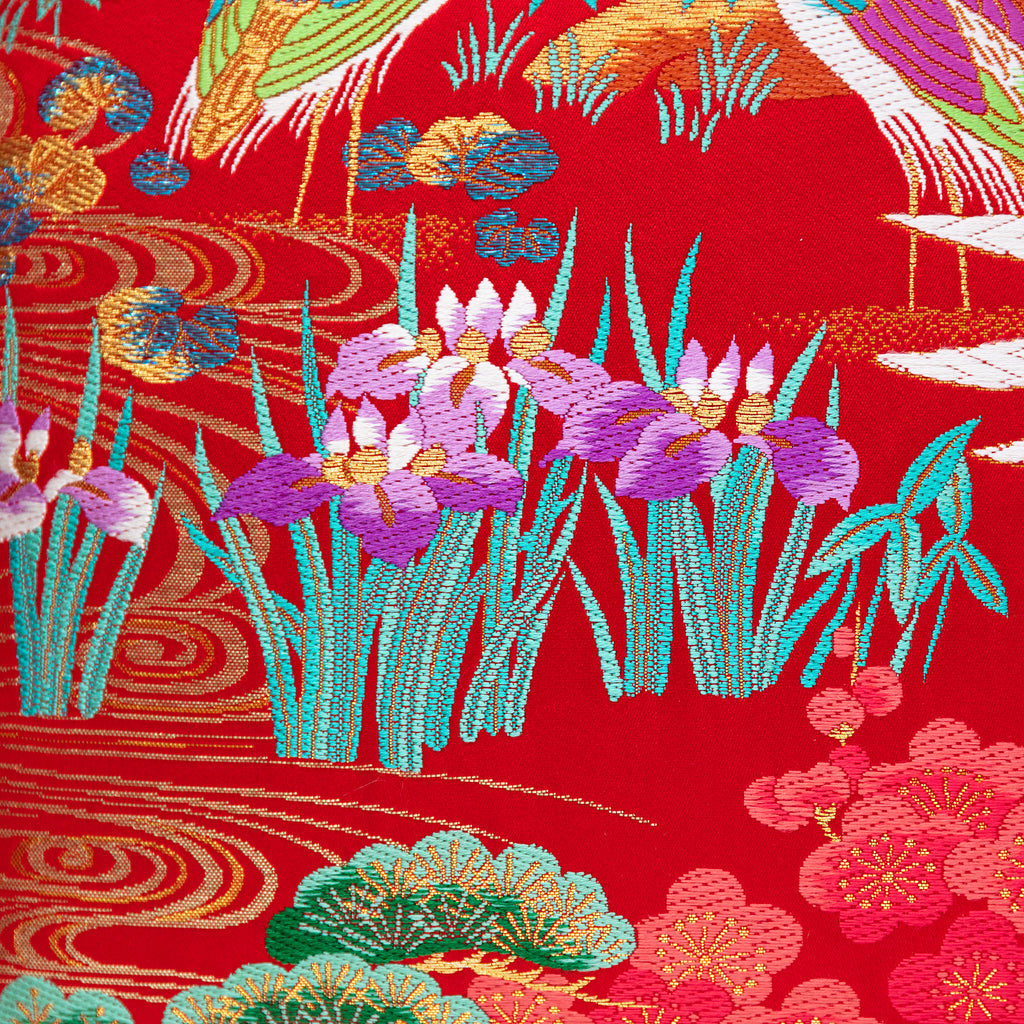 Close-up of the Uchikake square pillow's intricate gold velvet iris embroidery on rich red silk fabric, highlighting