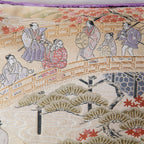 Close-up of purple velvet fabric highlighting intricate woven obi pattern and rich texture from a side angle.