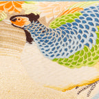 Close-up of cream Maru Obi silk embroidery detail on the pillow's corner, highlighting intricate stitching and luxurious