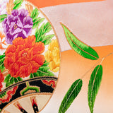 Japanese kimono silk pillow detail showing orange base, green bamboo leaves and floral embroidery