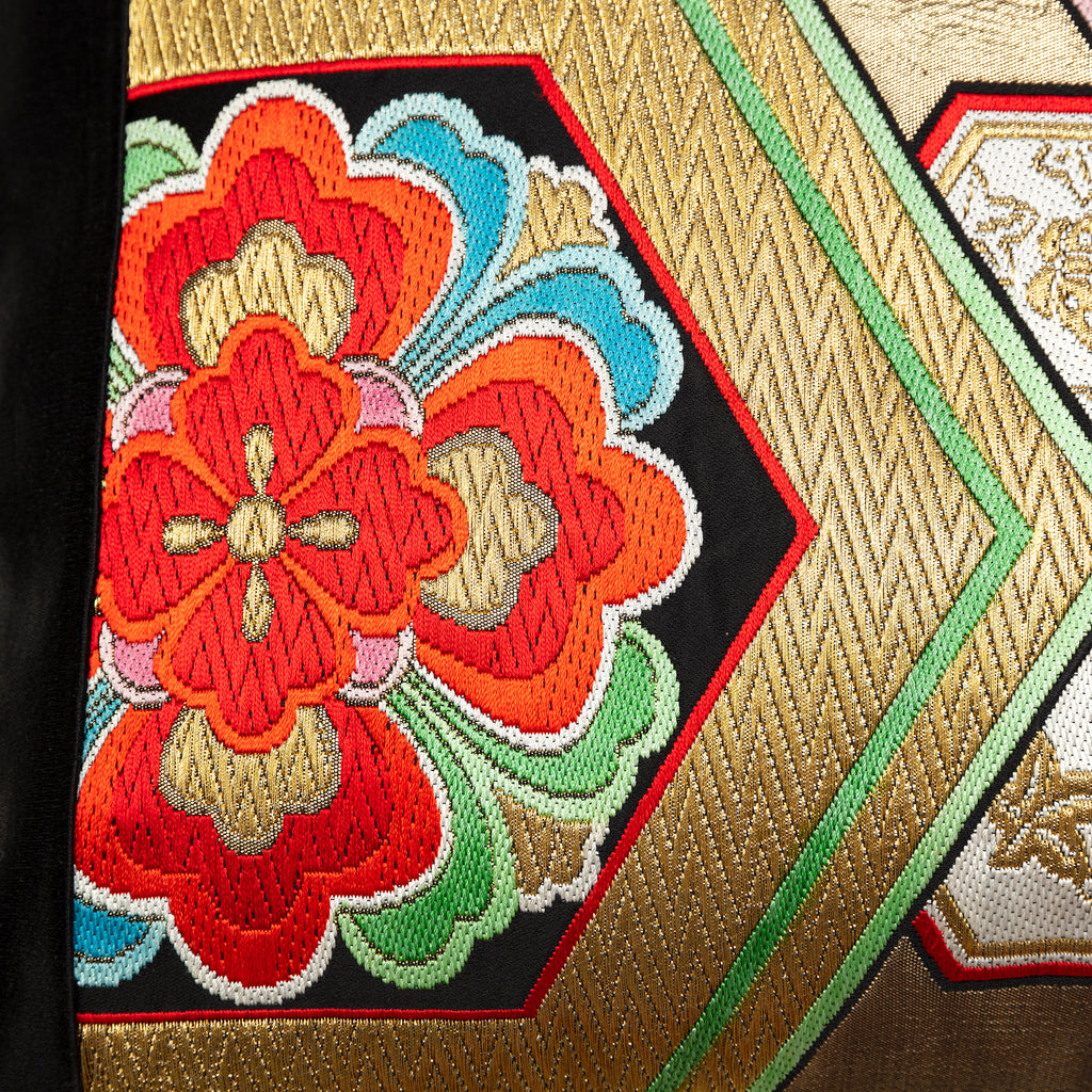 Close-up of the gold hexagon embroidery on black silk, highlighting intricate stitching and metallic thread texture of the