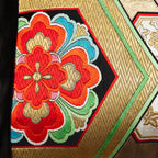 Close-up of the gold hexagon embroidery on black silk, highlighting intricate stitching and metallic thread texture of the