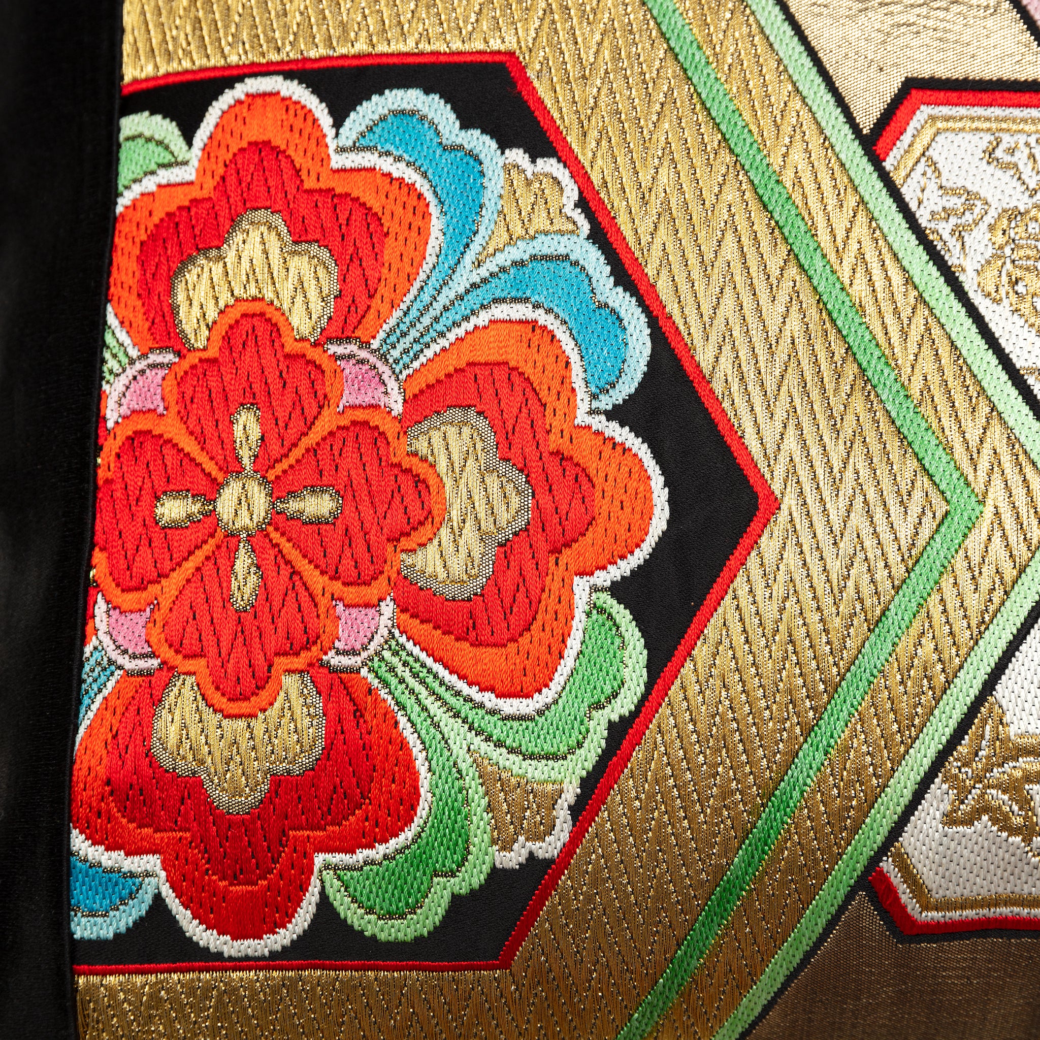 Close-up of the gold hexagon embroidery on black silk, highlighting intricate stitching and metallic thread texture of the