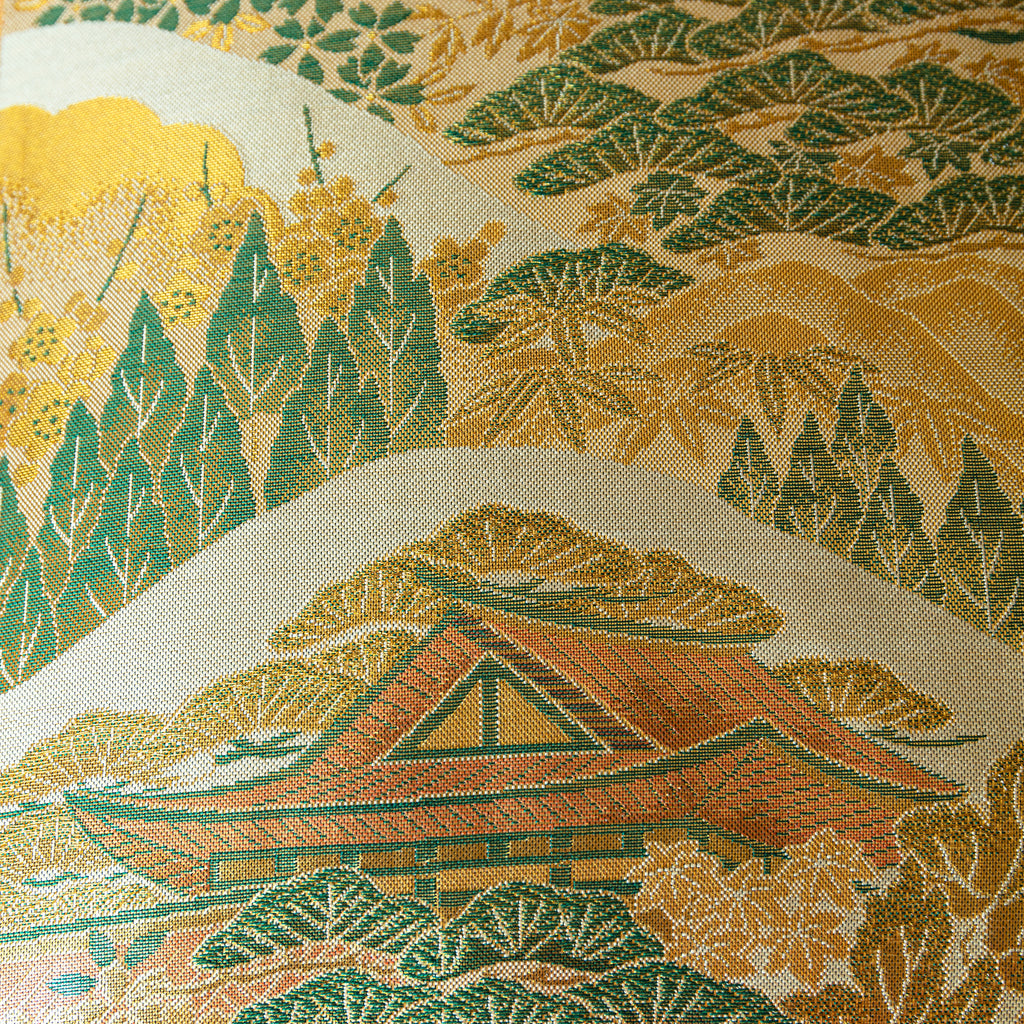 Close-up of the Nishijin kimono silk fabric showcasing intricate mountain temple embroidery and vibrant colors on the