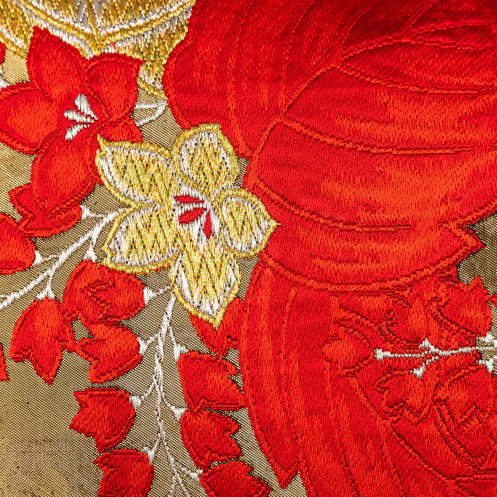 Close-up of the vibrant red and gold embroidered details on the vintage obi cushion fabric, highlighting intricate stitching