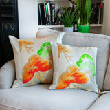 Large and medium sized cream throw pillows side by side on a couch.