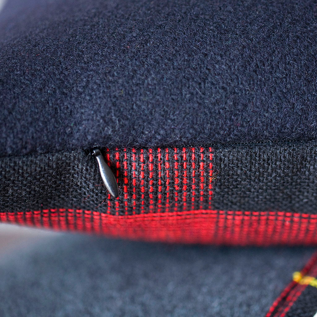 Close-up of the navy tartan fabric highlighting intricate woven pattern and rich texture of the vintage Gannex cushion edge