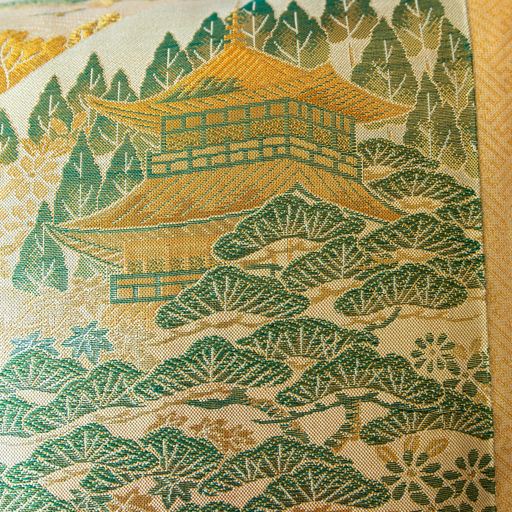 Close-up of the Nishijin kimono silk fabric showcasing intricate mountain temple embroidery and vibrant color details on the