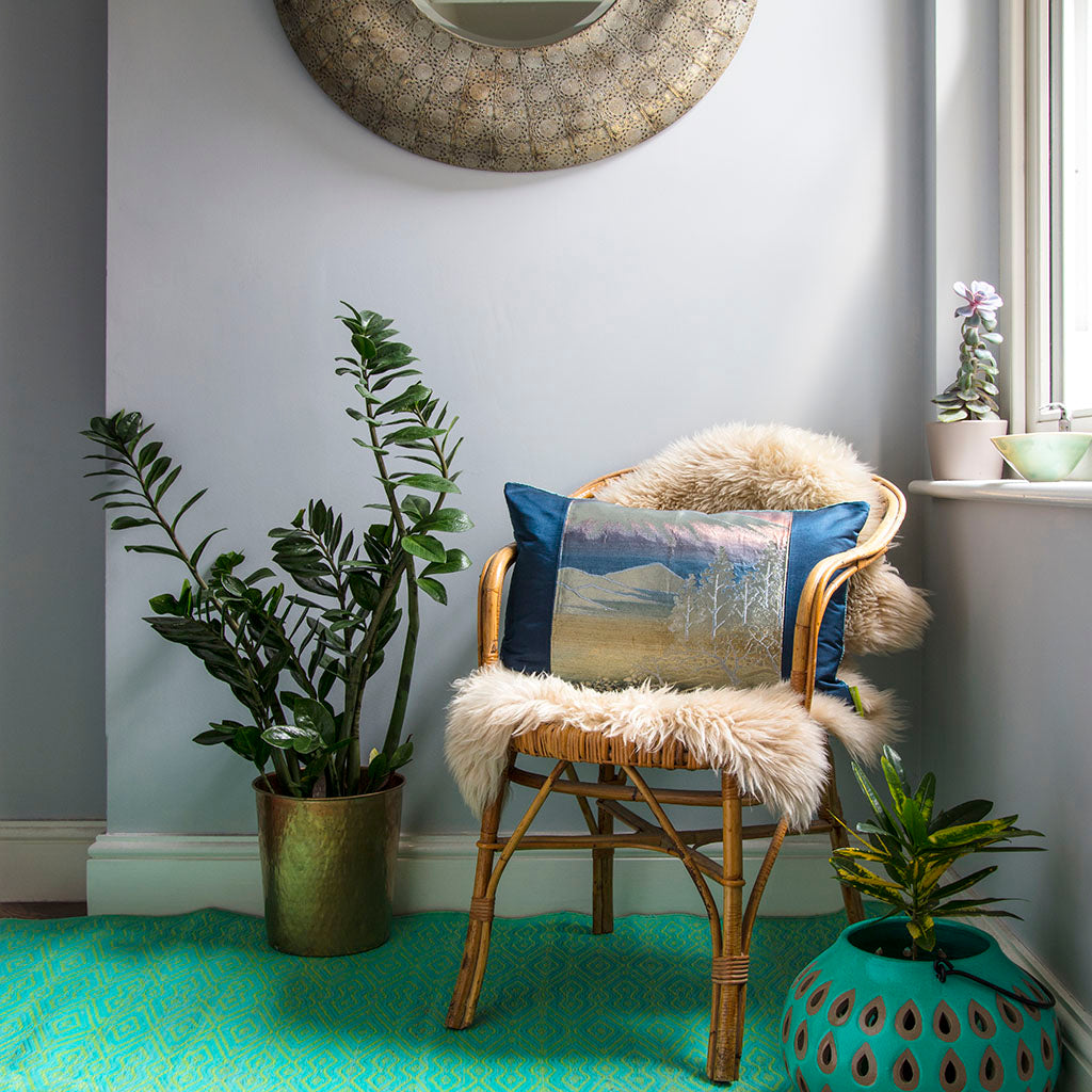 Close-up of the vibrant blue velvet fabric's rich silk sheen and intricate weave texture on the cushion's corner detail.