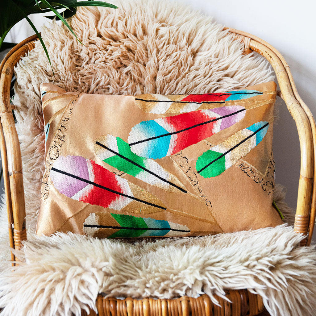 Close-up of gold gilt feather embroidery featuring metallic threads and silk texture on the Hollywood Regency kimono pillow