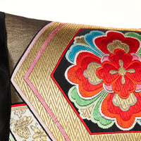 detail of oriental throw pillow with metallic gold thread.