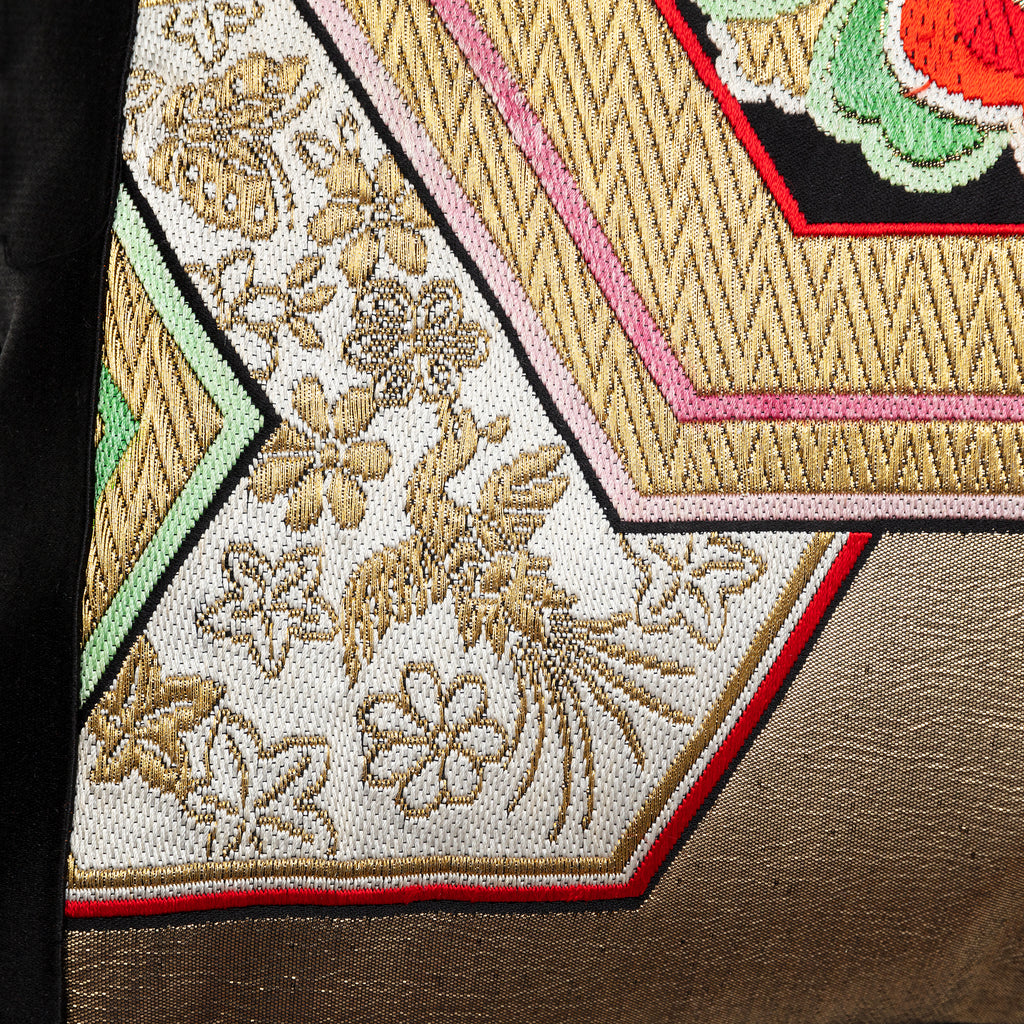 Close-up of the gold hexagon embroidery revealing textured silk threads and precise stitching on the vintage black silk