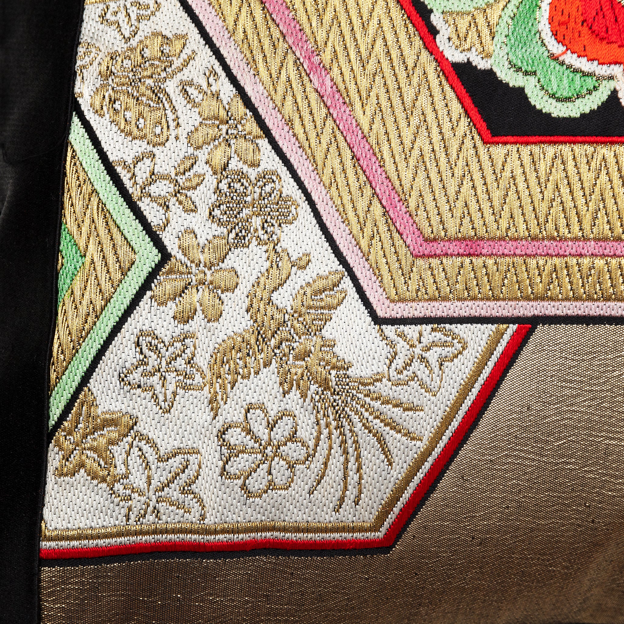 Close-up of the gold hexagon embroidery revealing textured silk threads and precise stitching on the vintage black silk