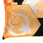 Close-up of the Chinoiserie pillow’s intricate gold and orange silk embroidery on black background, showcasing detailed
