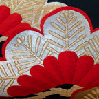 Close-up of the black silk obi pillow fabric showing gold velvet pines embroidery and textured surface detail