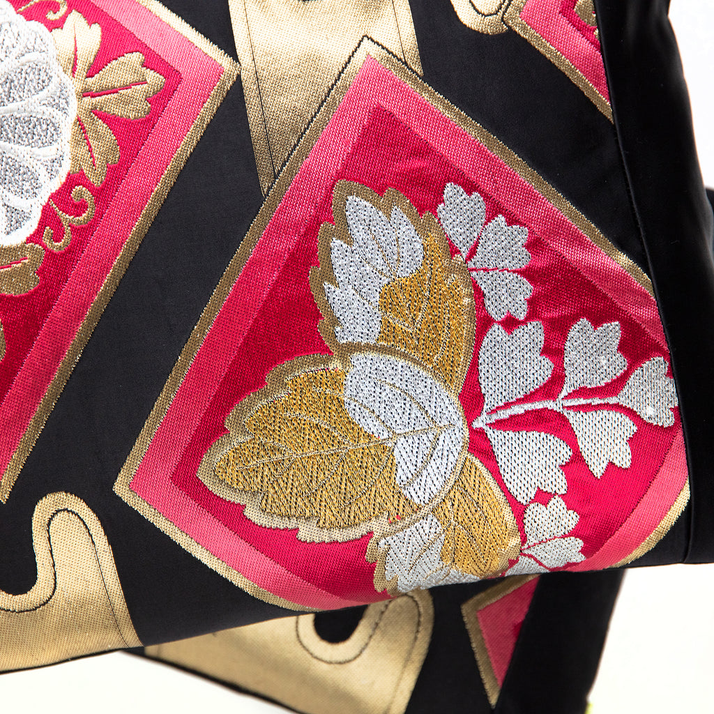 Close-up of black silk fabric with gold embroidered accents on the Pink Kimono Pillow, highlighting intricate texture details