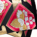 Close-up of black silk fabric with gold embroidered accents on the Pink Kimono Pillow, highlighting intricate texture details