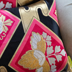 Close-up of gold embroidered accents on the black silk fabric of the Pink Obi Pillow Set, showcasing intricate detail and
