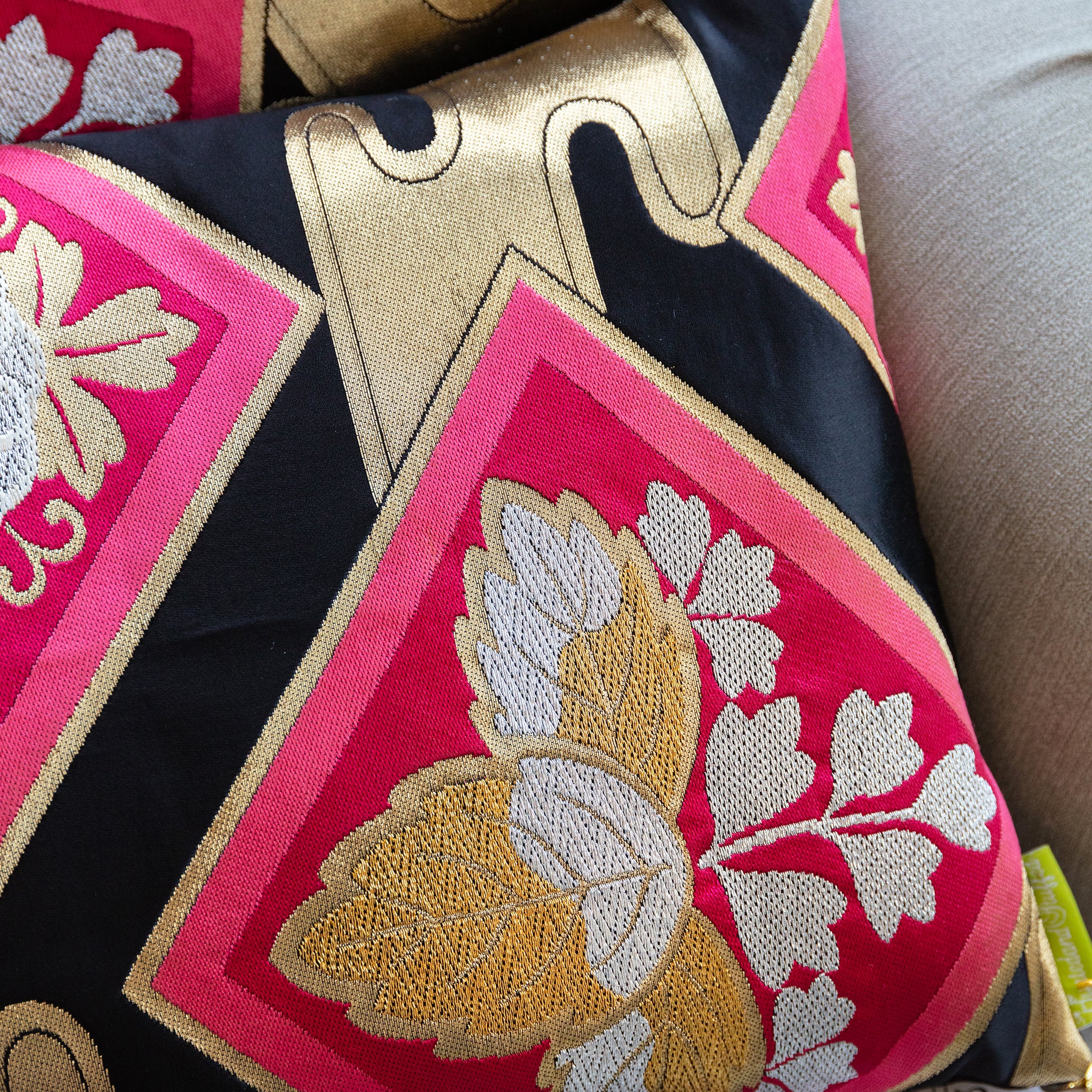 Close-up of gold embroidered accents on the black silk fabric of the Pink Obi Pillow Set, showcasing intricate detail and