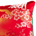 Close-up of emerald velvet corner with gold embroidered detail on the 13-inch red silk pillow, showcasing luxurious textures